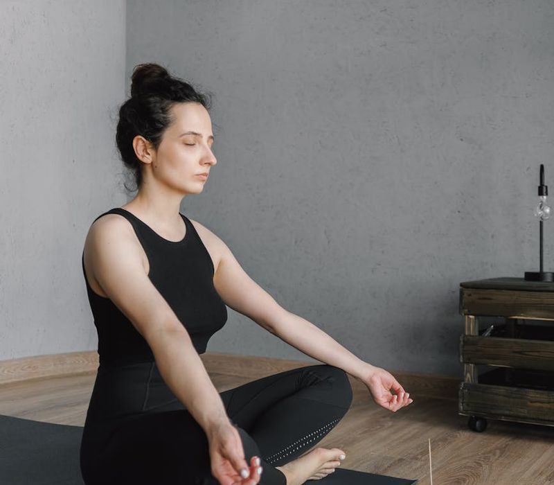 Woman practicing deep breathing in a bright, calm room.
